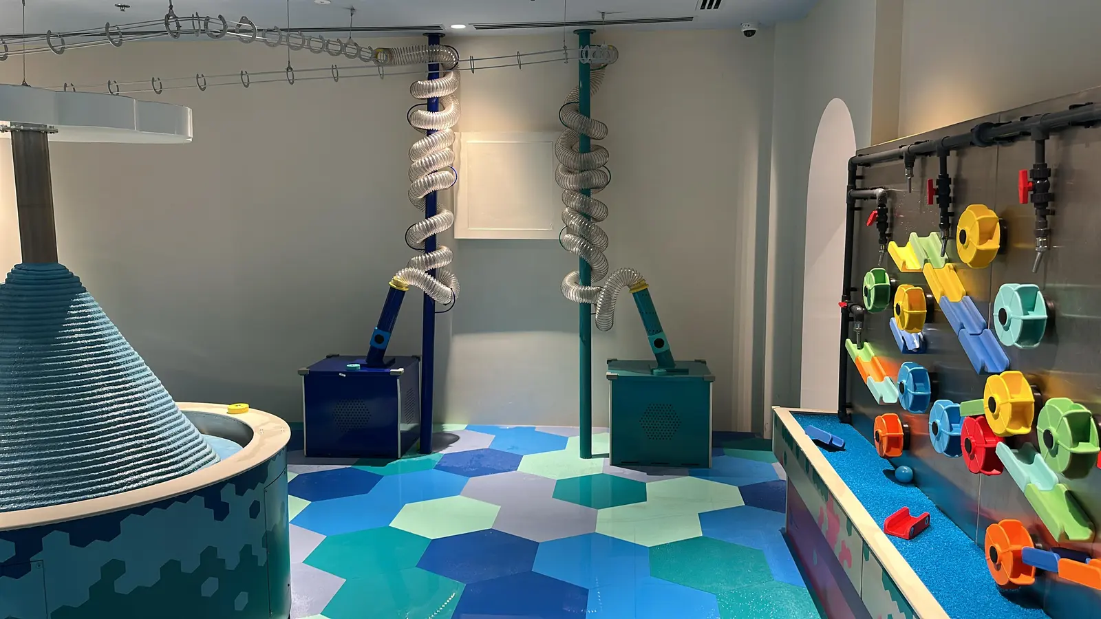 Overhead ball transport track above interactive water tables